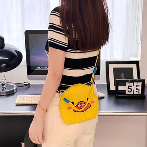 Detail of a cute yellow cartoon duck crossbody bag with colorful cords on a model.