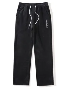 Comfortable men's black fuzzy fleece lounge pants featuring white drawstring and embroidery.
