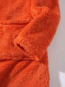 Close-up of bright orange fuzzy fleece hoodie showing soft texture and sleeve detail