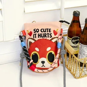 Detailed view of the red panda cartoon print and colorful rope strap on the bag.