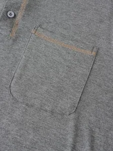 Vue rapprochée de la poche d'un polo gris avec surpiqûres contrastées et maille fine