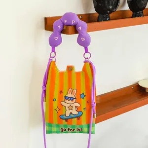 Detail view of a cartoon rabbit mini crossbody bag with a purple strap hanging on a shelf