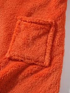 Close-up detail of soft orange plush fleece fabric with a functional front pocket