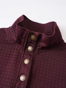 Primer plano de sudadera burdeos para hombre con cuello alto, botones metálicos y cuadros