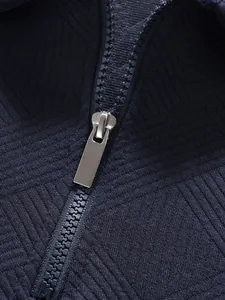 Detailansicht eines hochwertigen Metallreißverschlusses an einem marineblauen Polohemd