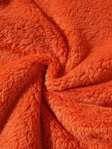 Macro detail shot showing the soft texture of bright orange plush sherpa fleece fabric