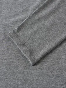 Gros plan du tissu en maille gris et du poignet d'un polo à manches longues pour hommes.
