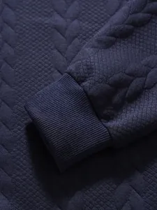Detailaufnahme der dunkelblauen Rippbündchen am strukturierten Langarm-Poloshirt