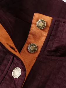 Primer plano de botones metálicos en una sudadera acolchada burdeos con cuello alto