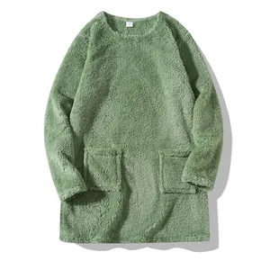 Close-up detail of a soft mint green fuzzy plush sweatshirt featuring two front pockets.