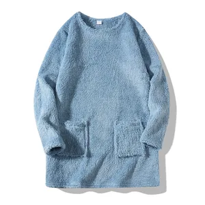 Close-up view of a light blue plush oversized sweatshirt with functional front pockets.