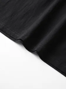 Close-up detail of black linen fabric texture and double-stitched hem on casual shirt