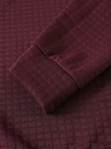 Detalle macro de sudadera granate de punto gofrado con textura de puño y rejilla