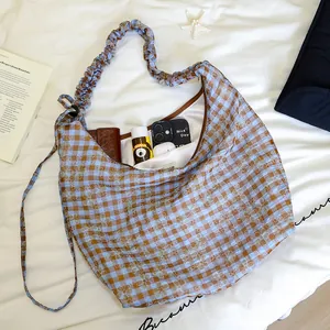 Borsa hobo a quadretti floreali con tracolla arricciata e oggetti quotidiani