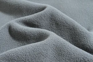 Primer plano macro de la textura y densidad del tejido de forro polar gris suave