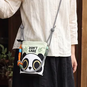 Close-up of panda print bucket bag with 'DON'T CARE' text and colorful rope detail