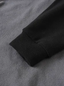 Detailansicht des weichen Polarfleece-Stoffes und der elastischen Manschette eines Herrenpullovers.