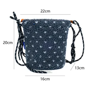Vista detallada de un bolso bandolera de forro polar gris con dimensiones y textura suave