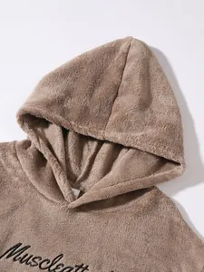 Macro detail of brown plush hooded loungewear featuring elegant black embroidery