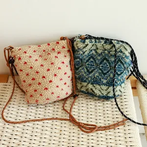 Primer plano de bolsos de lana de cordero con textura estampada y correas de cordón.