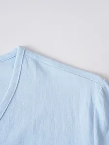 Close-up detail of light blue breathable linen V-neck shirt showing fabric texture