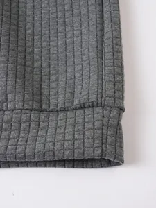 Primer plano de la textura de rejilla gris en una sudadera informal de hombre.
