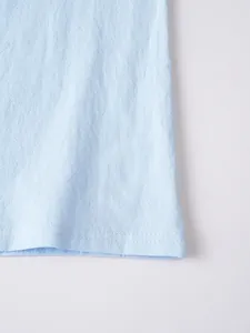 Macro view of light blue linen fabric texture and double-stitched hem on men's casual shirt