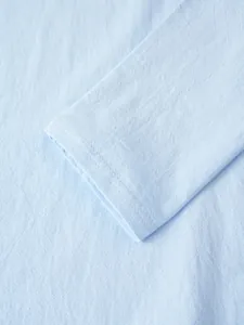 Detailed close-up showing the breathable linen fabric texture and cuff of this light blue shirt