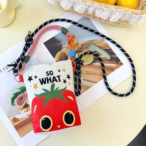 Close-up detail of cartoon strawberry print on a canvas crossbody bucket bag with rope strap