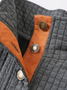 Primer plano de botones metálicos y textura acolchada en sudadera casual para hombres