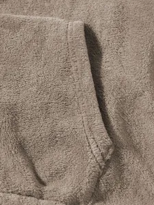 Macro detail shot showing the soft plush fleece fabric texture and durable stitching on tracksuit