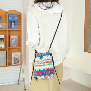 Vista detallada de un bolso bandolera de felpa con diseño bohemio usado por una modelo