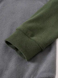 Nahaufnahme des weichen grünen Polar-Fleece-Bündchens an einem grauen Sweatshirt-Detail