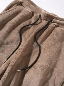 Close-up of plush fleece fabric and adjustable black drawstring on pants waistband