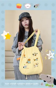 Close-up of yellow Japanese style embroidered tote bag with cute dog patterns