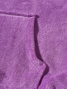 Close-up detail of soft purple fleece fabric texture on a cozy winter hoodie.