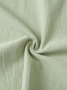 Close-up macro shot of light green linen fabric texture showing breathable weave