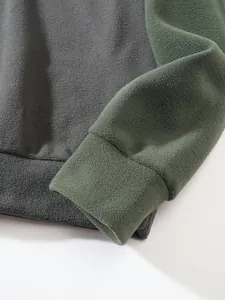 Nahaufnahme des olivgrünen Fleece-Ärmelbündchens und grauen Saums des Herren-Outdoor-Sweatshirts.