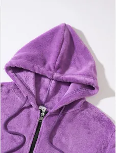 Close-up macro detail of a soft purple fleece hoodie with zipper and drawstring