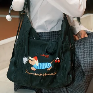 Detalle del bolso bandolera de nailon negro con lindo bordado de teckel y diseño casual
