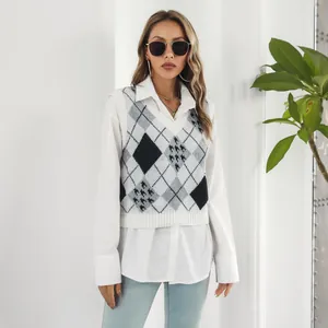 Dettaglio del gilet in maglia da donna con motivo a rombi e pied-de-poule sopra camicia