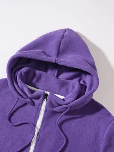 Κοντινό πλάνο μωβ φούτερ fleece με κουκούλα, μαλακή υφή και λευκό φερμουάρ.