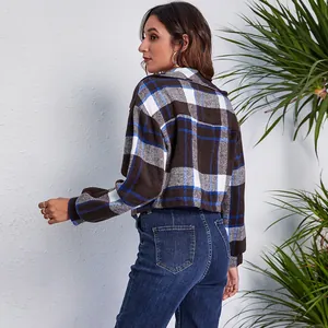 Back view detail of a woman wearing a brown and blue plaid lantern sleeve short jacket