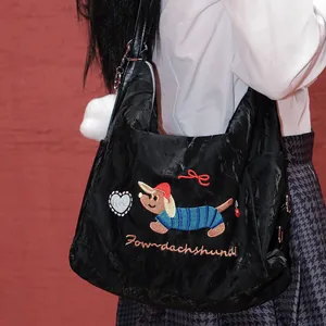 Detalle de bolso negro estilo Harajuku con bordado de perro salchicha y corazón.