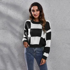 Detailed view of the black and white checkerboard pattern on a short loose knit sweater