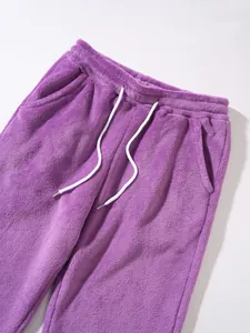 Close-up of purple plush pants with white drawstring and elastic waistband detail.