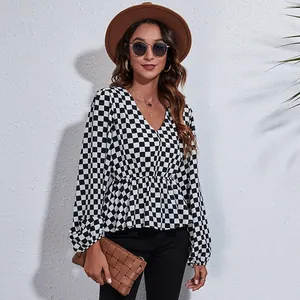Lifestyle detail of V-neck checkered blouse with lantern sleeves and cinched waist design