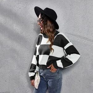 Close-up of checkerboard knit sweater with drop-shoulder and long sleeves design.