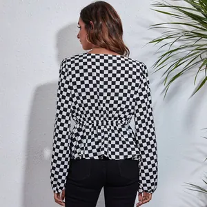 Back view of a black and white checkered chiffon blouse with elastic waist and lantern sleeves