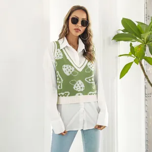Detalle de un chaleco de punto verde con cuello en V y un lindo patrón de hongos blancos